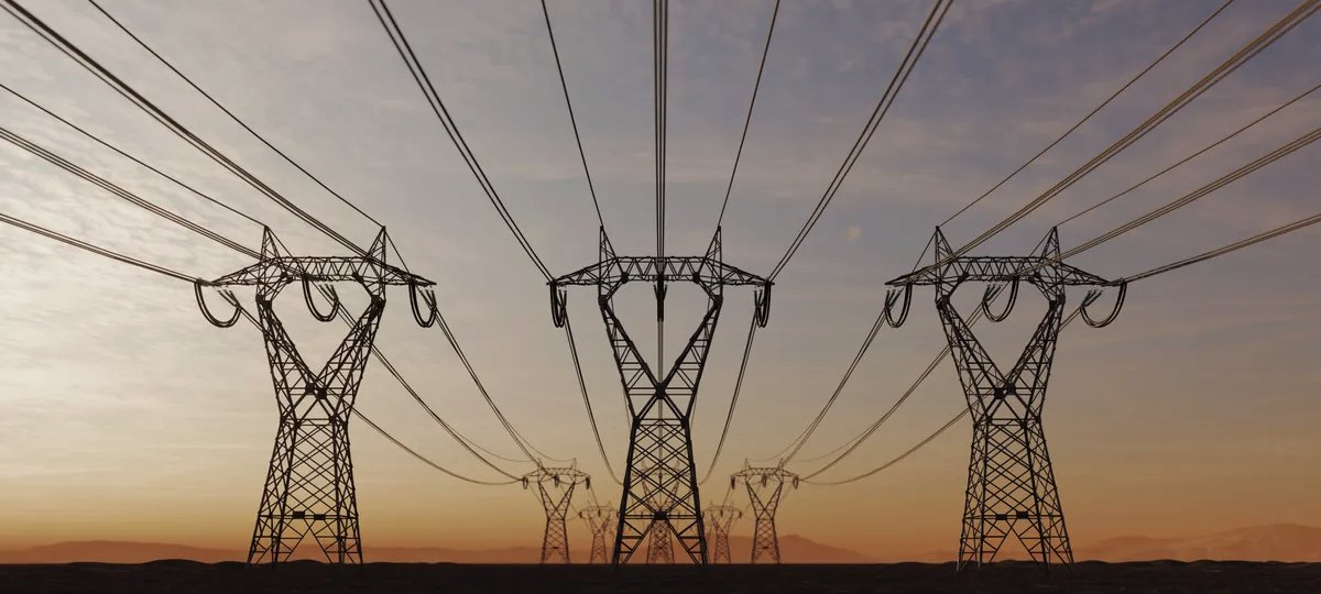 Three high-voltage transmission towers carrying their lines towards the horizon at dusk