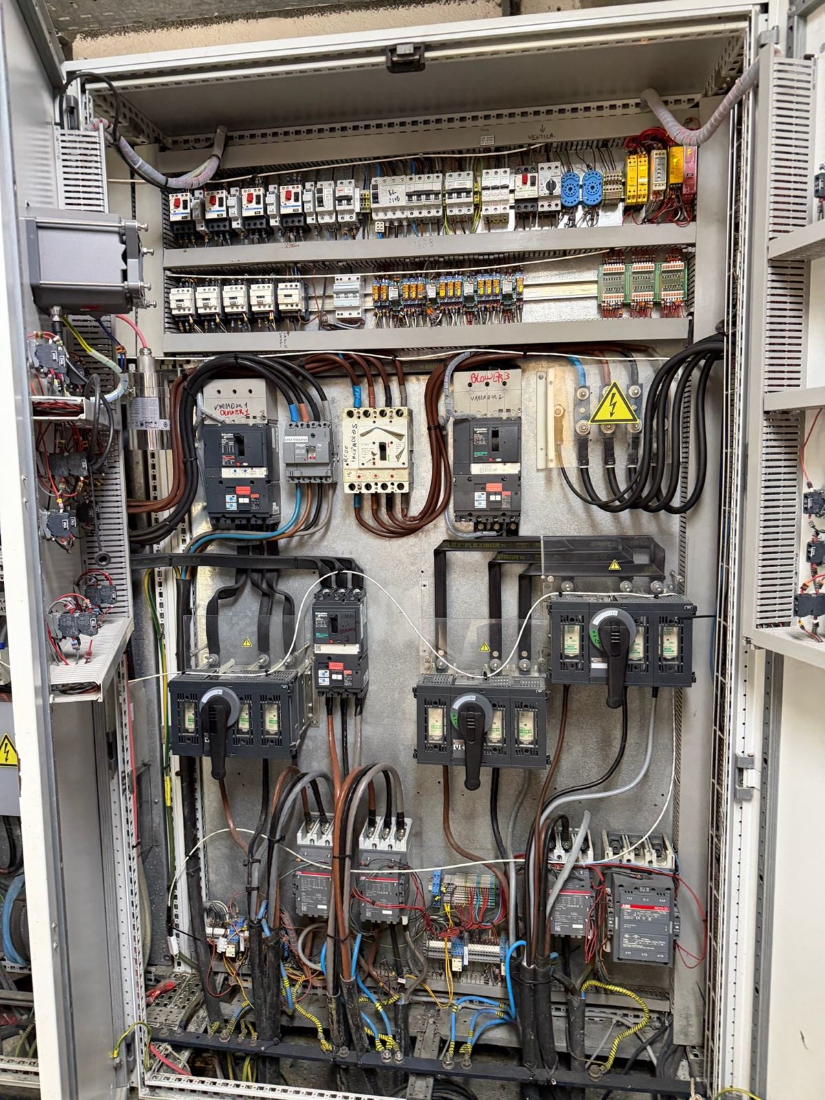 An open control cabinet packed with contactors, relays and wiring