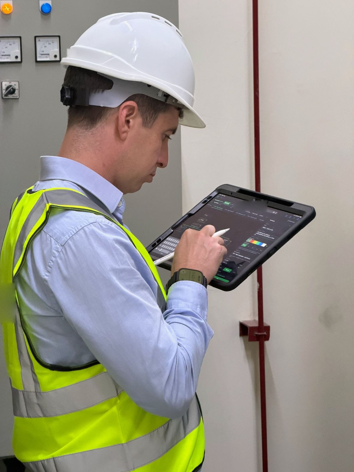 A member of the HarmoniQ team in a hard hat drawing a site’s single-line diagram on a tablet