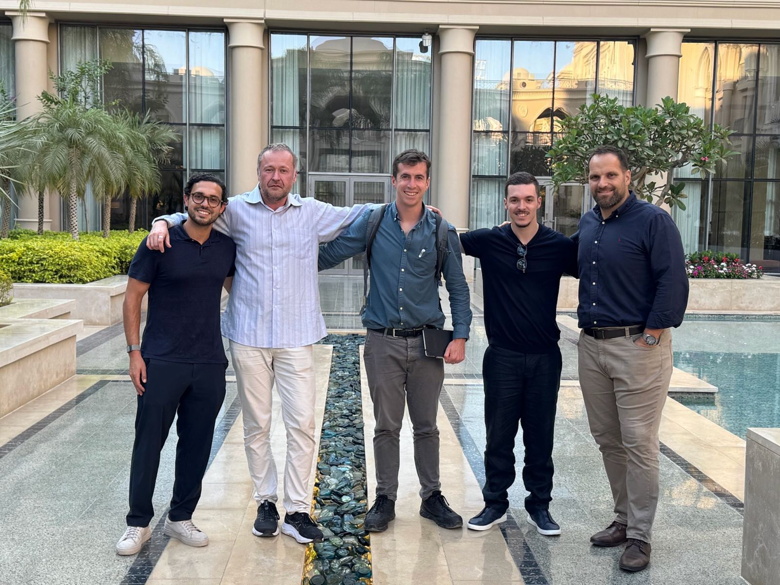 Five of the HarmoniQ team standing together in a hotel courtyard in Giza